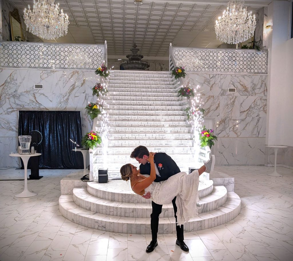 Couple's dip on a grand staircase framed by cold sparks