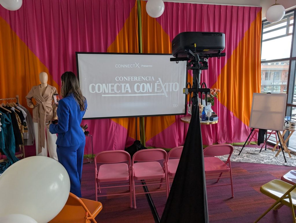 Projection screen on a stand in front of a colorful draped backdrop