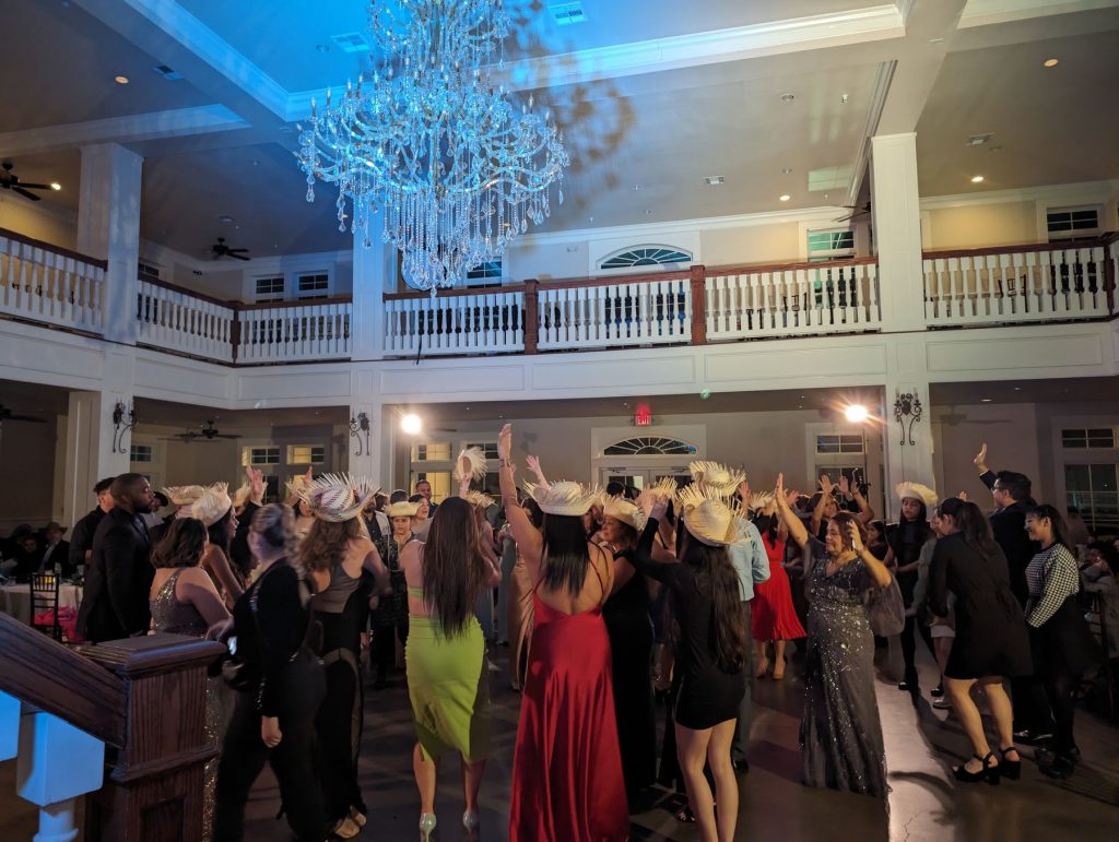 Guests filling the dance floor under a chandelier in a two-level ballroom