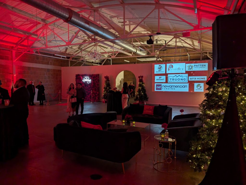 Holiday party lounge with red uplighting and a projection screen