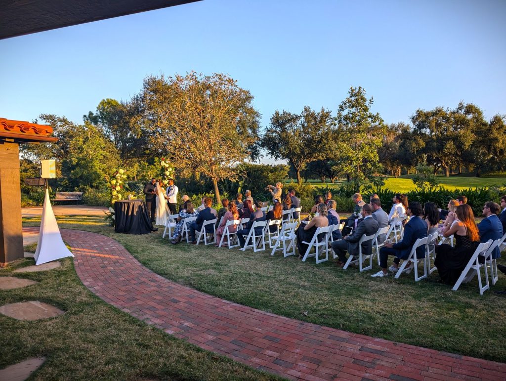 Guests seated on the lawn for an outdoor garden ceremony