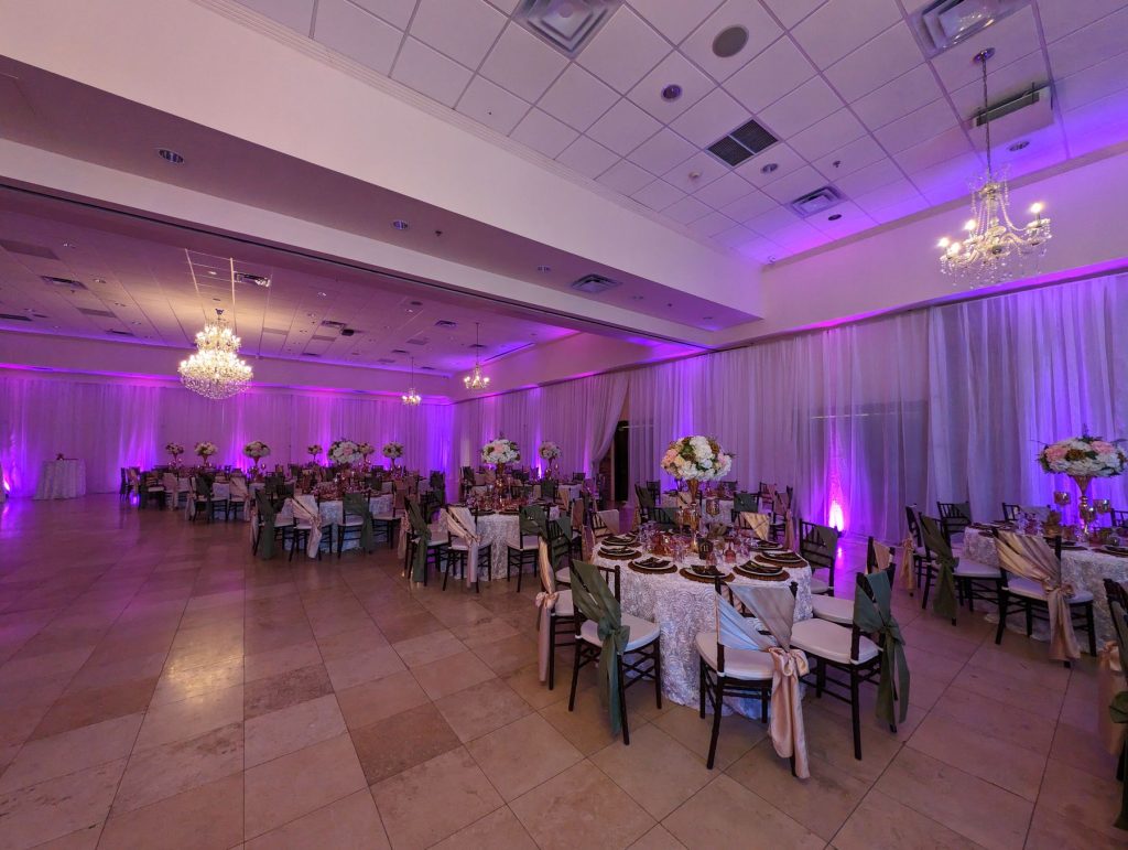 Reception hall with purple uplighting and set tables