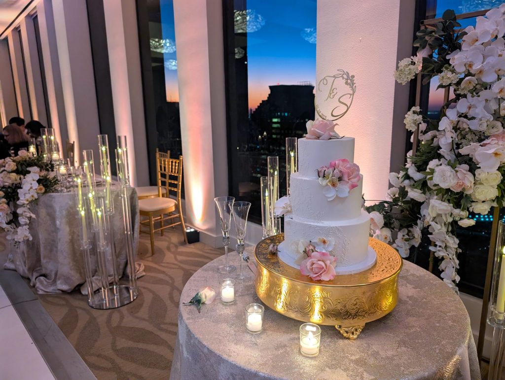 Wedding cake on a gold stand with candlelight